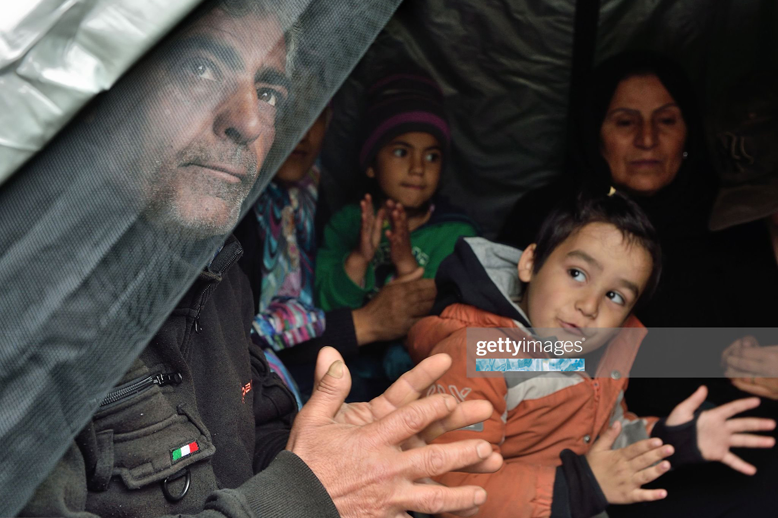 A Kurdish refugee family plays traditional music inside their tent at a makeshift camp at the Greek-Macedonian border, near the Greek village of Idomeni on March 16, 2016, where thousands of refugees and migrants are stranded by the Balkan border blockade. / AFP / DANIEL MIHAILESCU        (Photo credit should read DANIEL MIHAILESCU/AFP via Getty Images)