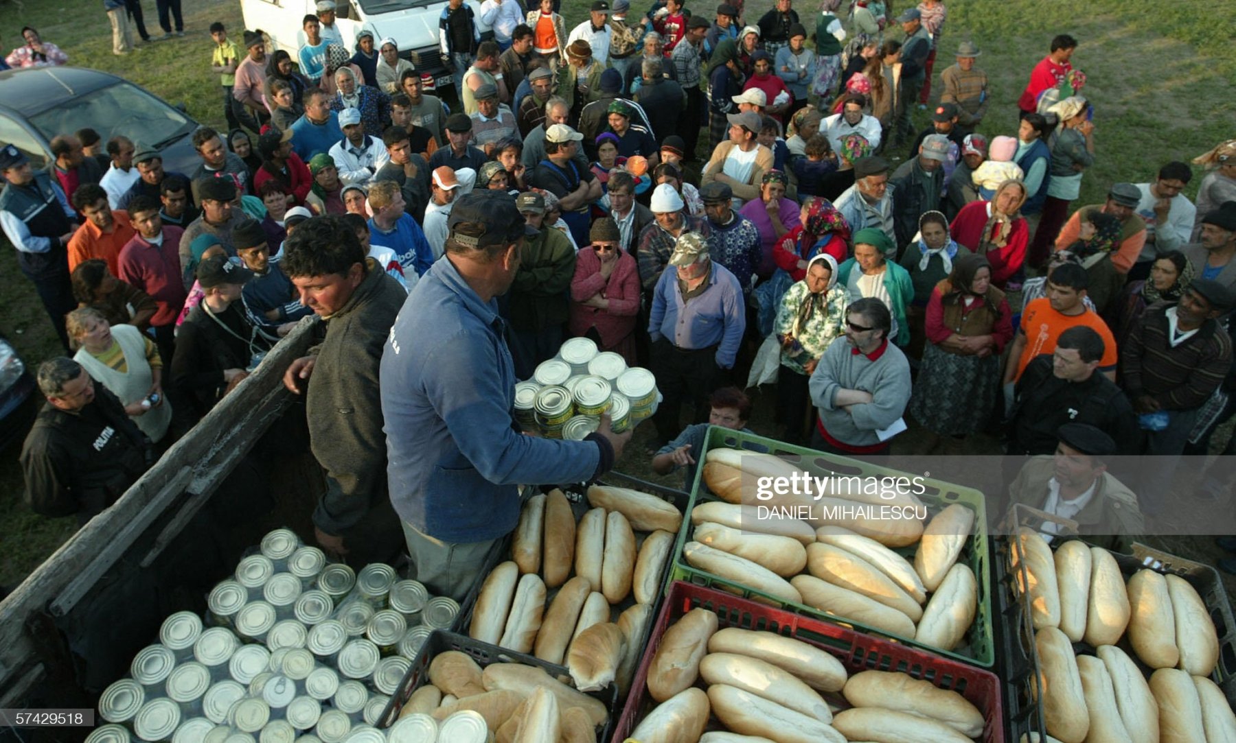 SPANTOV, ROMANIA:  Local authorities offer bread and meat cans to the refugees at the improvised camp on a hill near Spantov village, 100km south from Bucharest, 26 April 2006. Thousands of residents have been evacuated from several Danube villages in western Romania and thousands more are under threat as the river hit near-record levels in Romania and Bulgaria. AFP PHOTO DANIEL MIHAILESCU.  (Photo credit should read DANIEL MIHAILESCU/AFP via Getty Images)